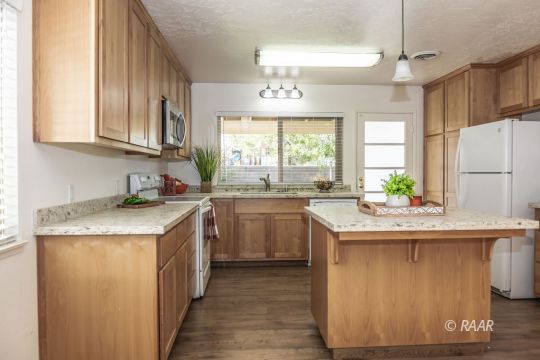 437 Peg Street Ridgecrest, CA 93555 - Photo 4 of 35 a kitchen with kitchen island granite countertop a sink appliances cabinets and a counter top space