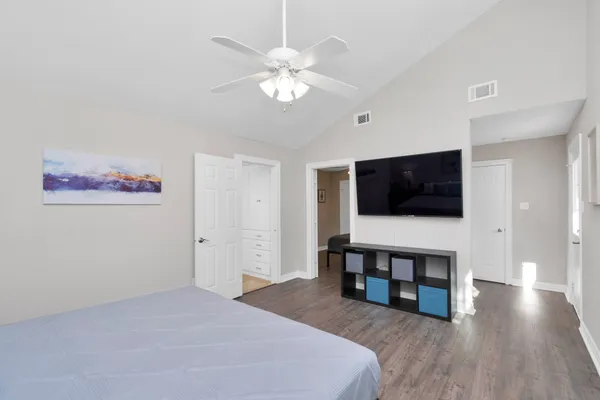 a spacious bedroom with a bed and a flat screen tv