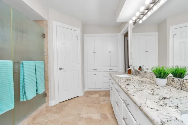 a bathroom with a granite countertop sink a large mirror and a bathtub