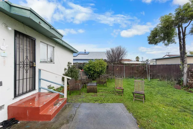 a backyard of a house with seating space and trampoline