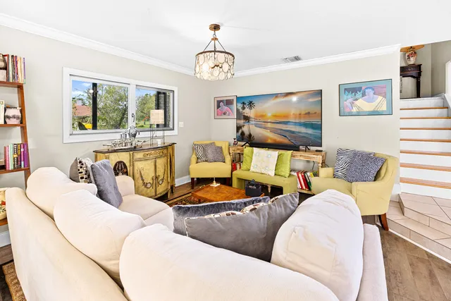 a living room with furniture a flat screen tv and a large window