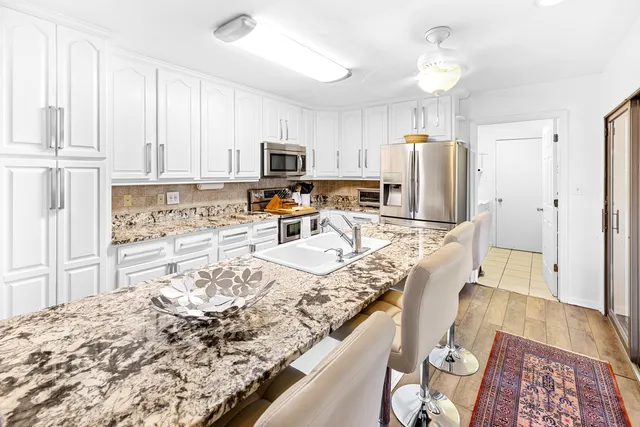 a kitchen with stainless steel appliances granite countertop a sink refrigerator and microwave