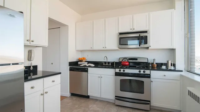 a kitchen with white cabinets and white appliances