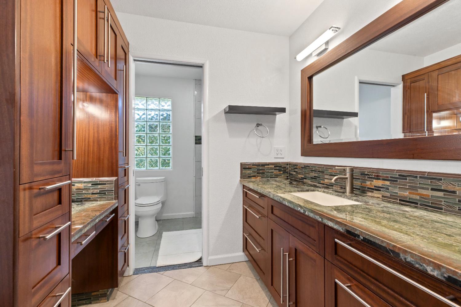 908 Newcastle Court Modesto, CA 95355 - Photo 15 of 25 a bathroom with a granite countertop sink a toilet and a mirror
