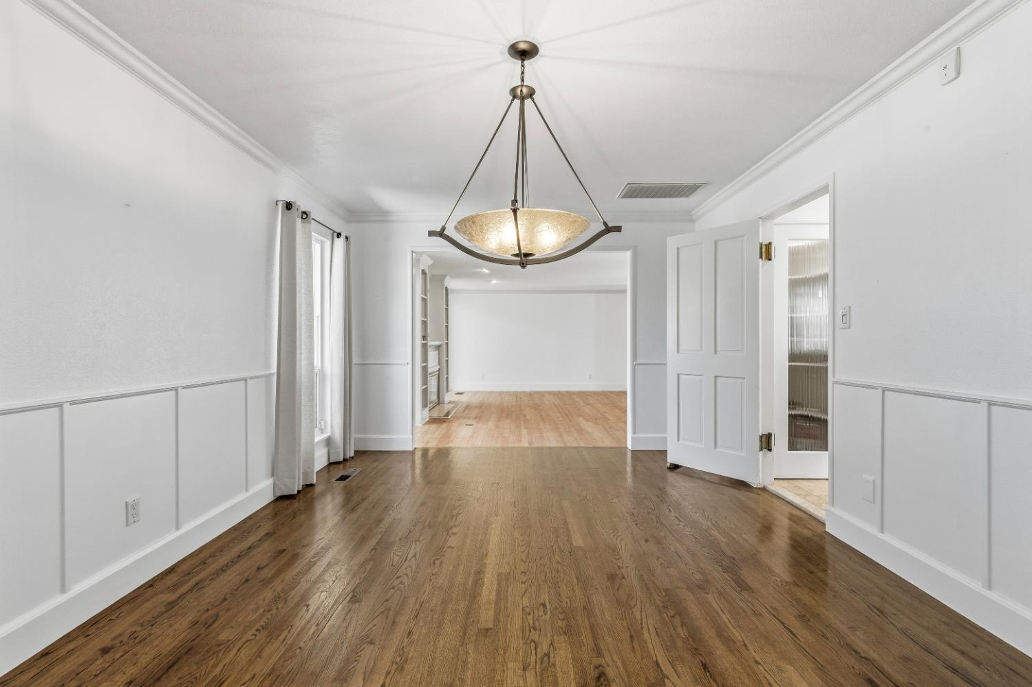 908 Newcastle Court Modesto, CA 95355 - Photo 6 of 25 a view of a room with wooden floor door and a chandelier