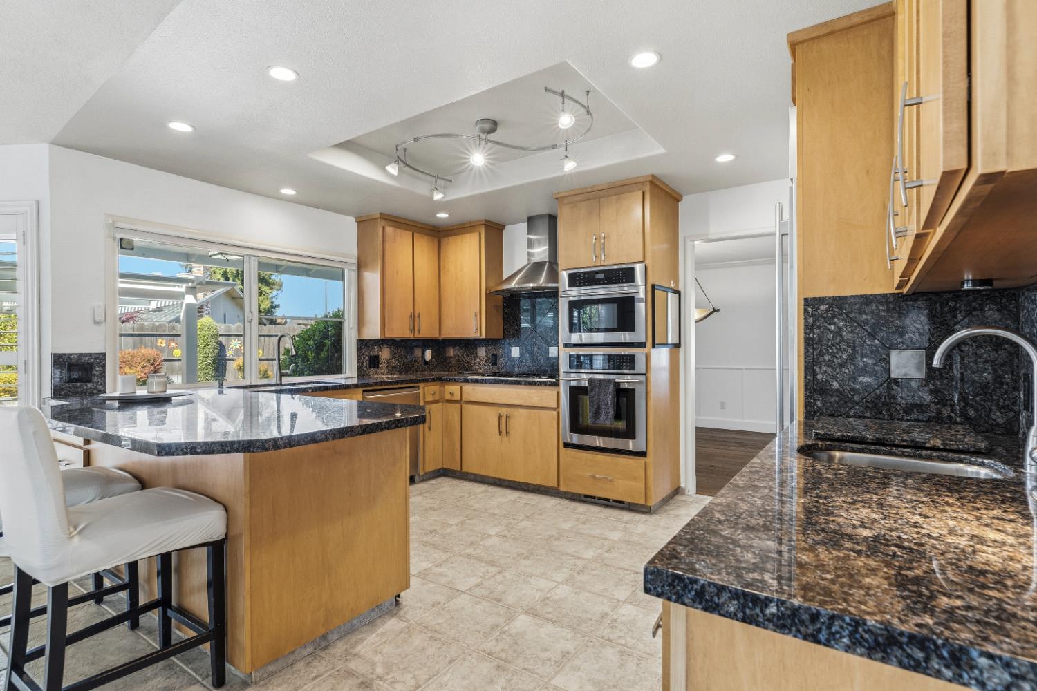 908 Newcastle Court Modesto, CA 95355 - Photo 10 of 25 a kitchen with kitchen island granite countertop a stove a sink and a refrigerator