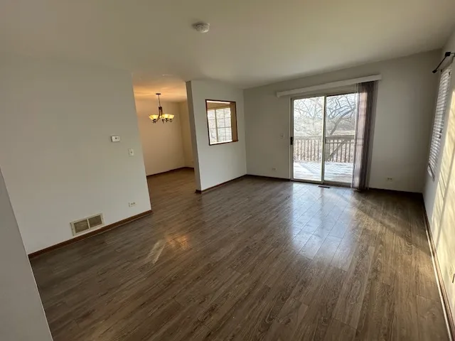 a view of a room with wooden floor cabinets and a chandelier