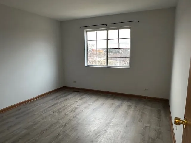 an empty room with wooden floor and a window