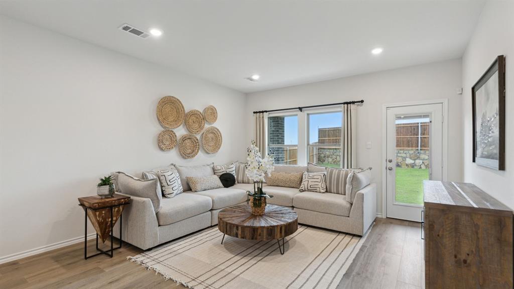 140 Pheasant Run Road Terrell, TX 75160 - Photo 10 of 26 Open-concept living space featuring wood-finish flooring, recessed lighting, large windows with black trim, and a glass-paneled door leading to the exterior