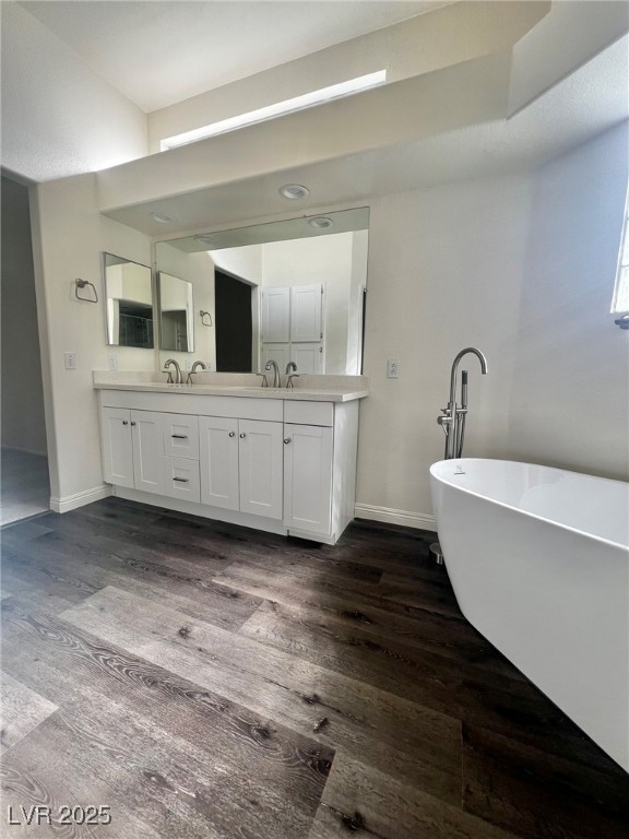 6656 Goldencreek Way, Unit HOME Las Vegas, NV 89108 - Photo 14 of 22 Bathroom featuring double vanity, a freestanding bath, and dark wood-type flooring