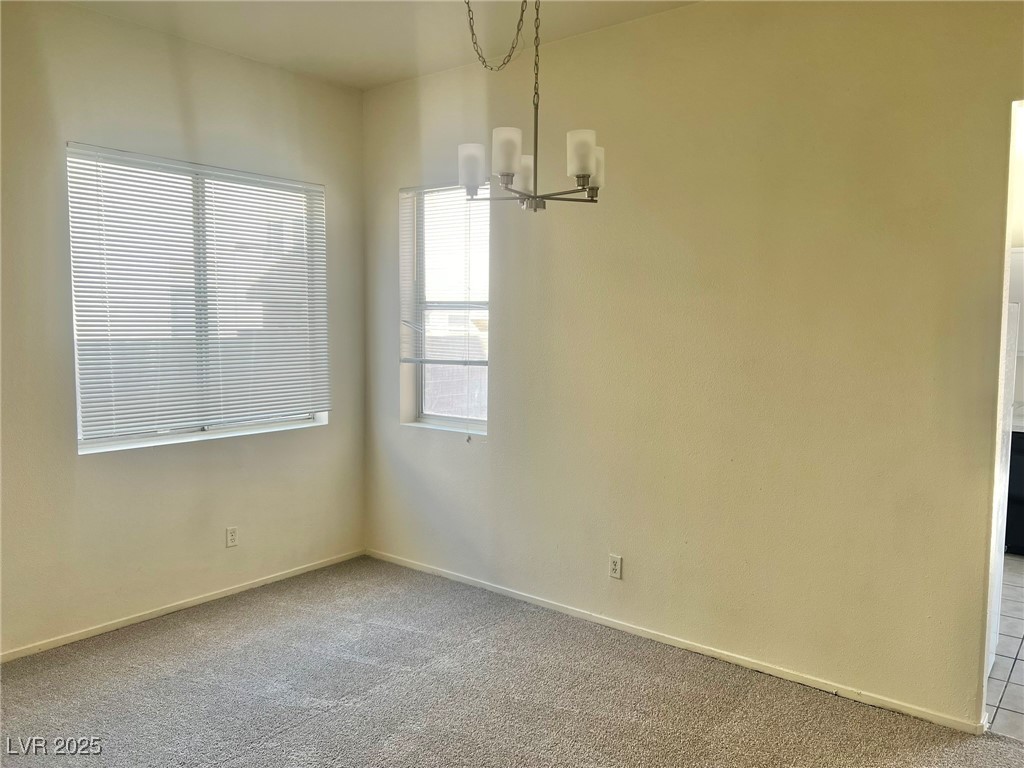 6656 Goldencreek Way, Unit HOME Las Vegas, NV 89108 - Photo 3 of 22 Empty room featuring carpet flooring and a chandelier