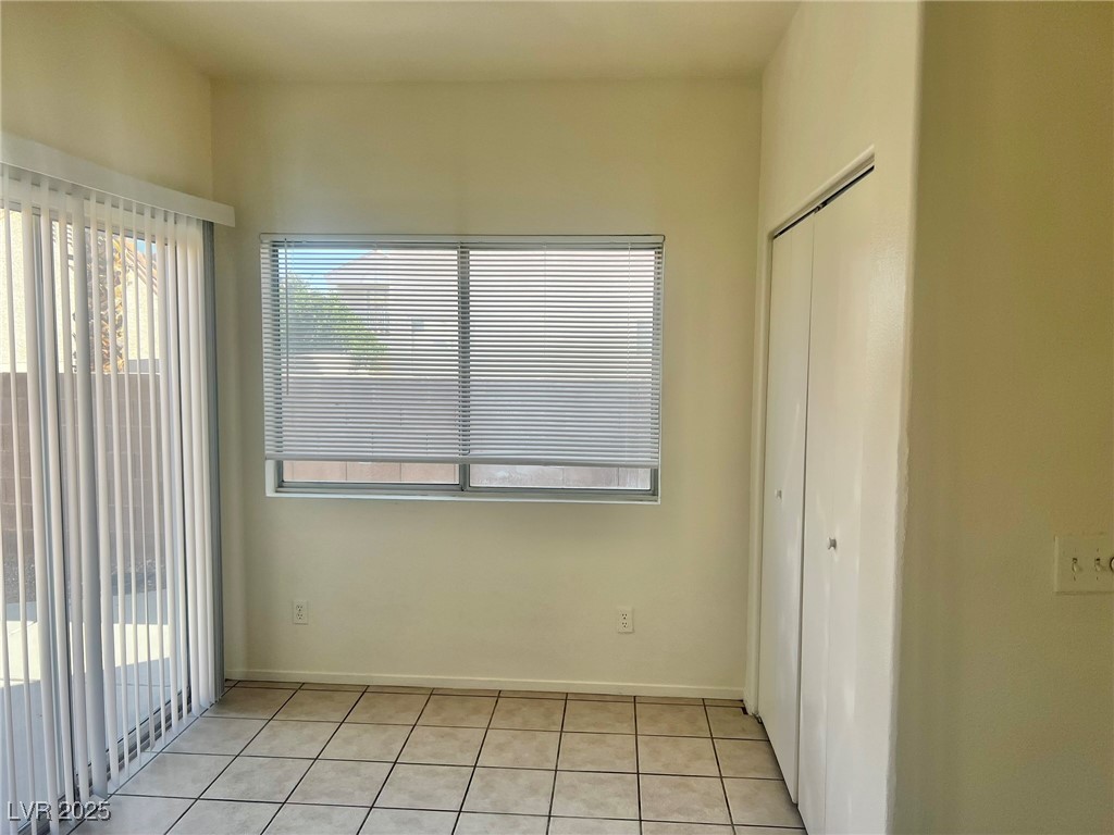 6656 Goldencreek Way, Unit HOME Las Vegas, NV 89108 - Photo 7 of 22 Unfurnished bedroom featuring multiple windows, light tile patterned floors, a closet, and access to outside