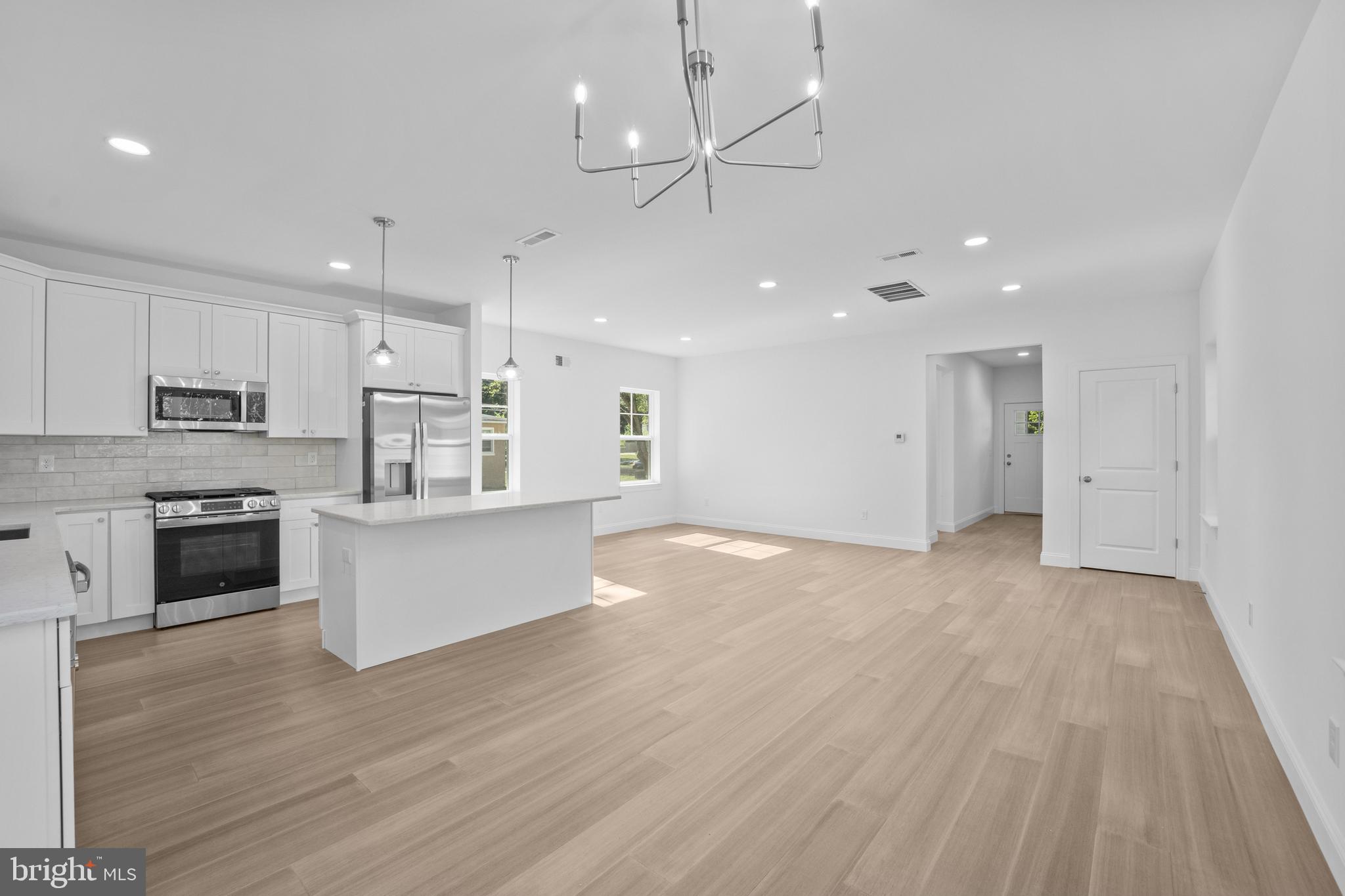 492 Ellis Avenue Lawnside, NJ 08045 - Photo 15 of 33 a large kitchen with stainless steel appliances granite countertop a large center island a sink dishwasher a refrigerator and white cabinets with wooden floor