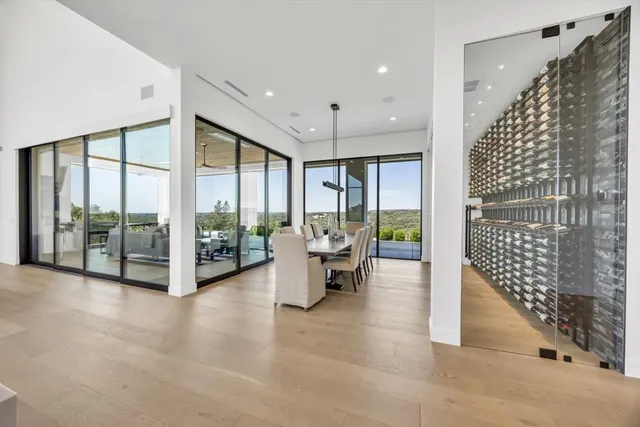 a living room with furniture floor to ceiling window and a flat screen tv