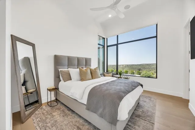 a bedroom with a large bed and a flat tv screen on dresser