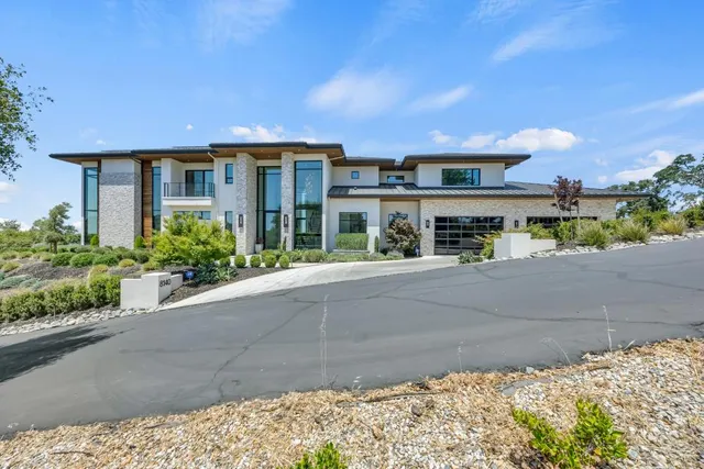 a kitchen with stainless steel appliances kitchen island granite countertop a table chairs sink and cabinets