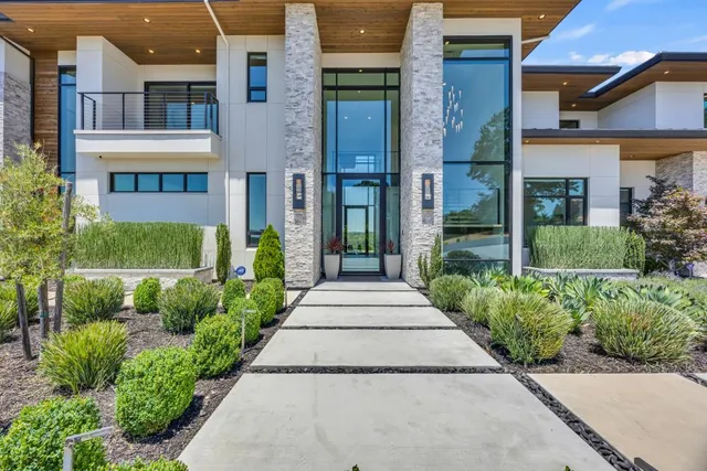 a kitchen with stainless steel appliances kitchen island granite countertop a table chairs sink and cabinets