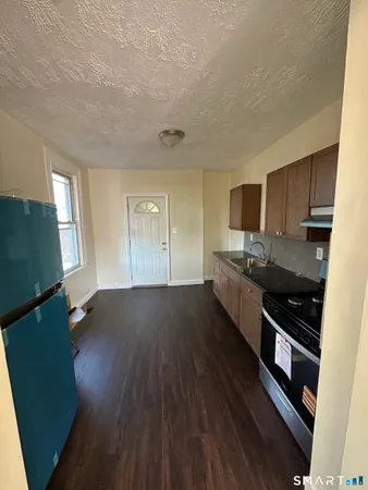 a kitchen with stainless steel appliances wooden floors and wooden cabinets