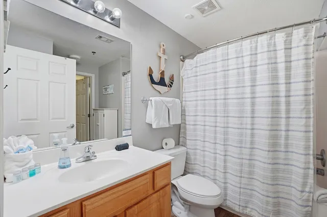 a bathroom with a sink a toilet and shower curtain