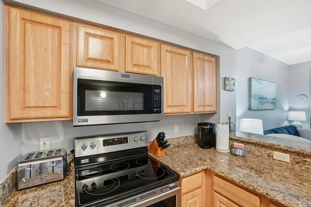 a kitchen with granite countertop a stove sink and microwave