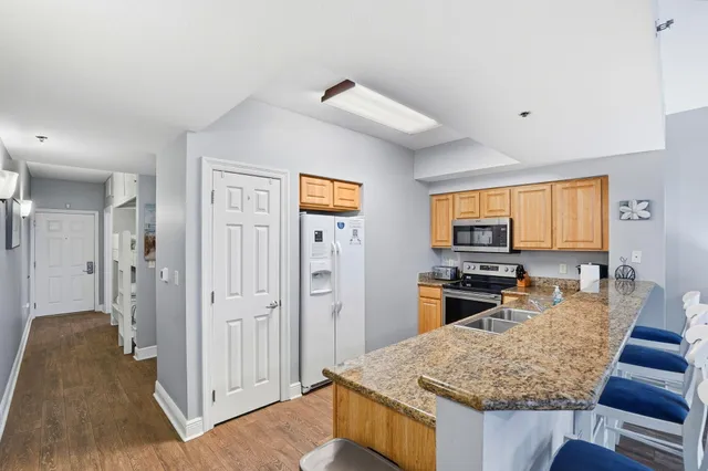 a kitchen with sink refrigerator and microwave