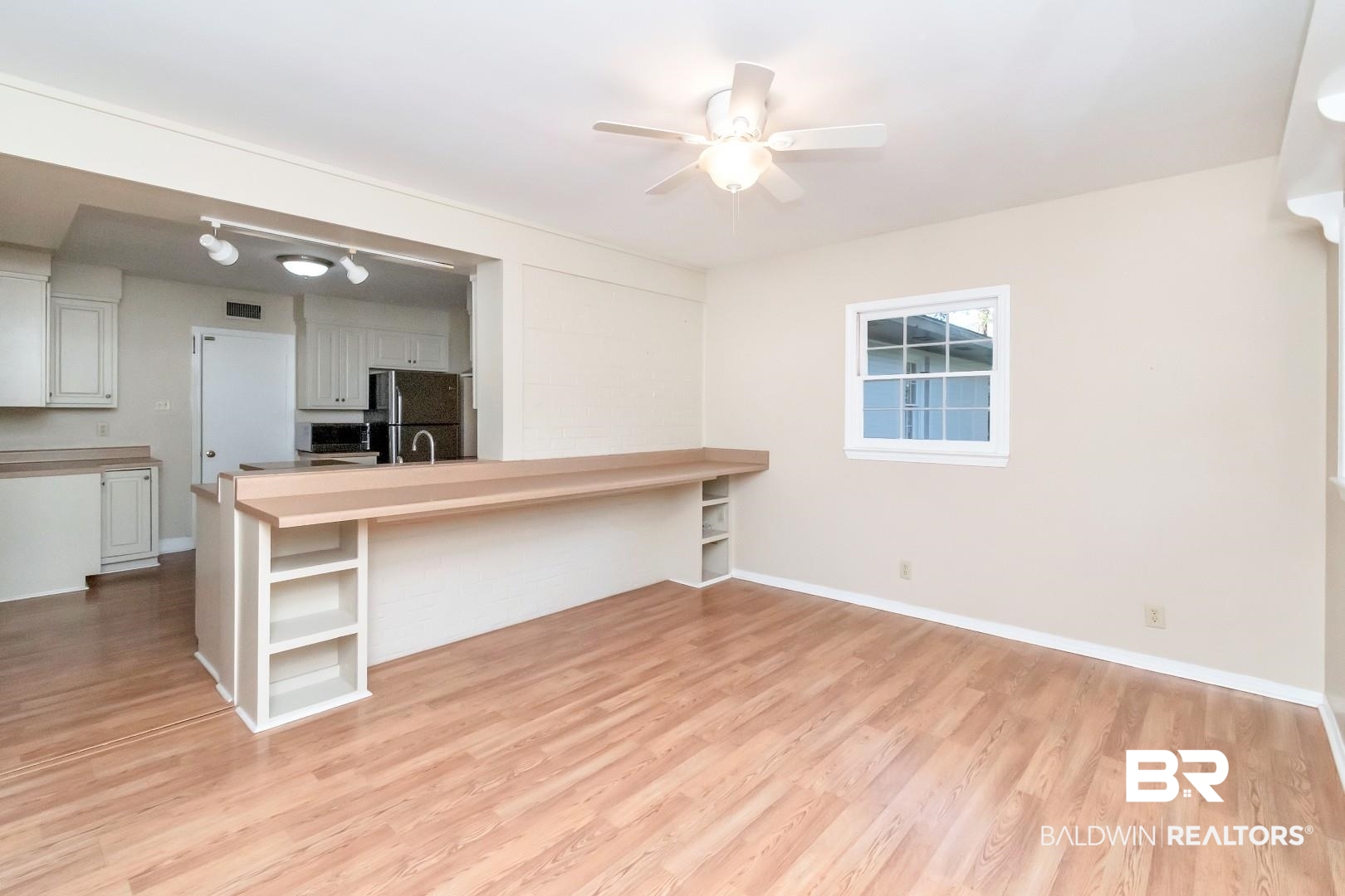 308 Brawood Drive Mobile, AL 36608 - Photo 11 of 33 Kitchen with black fridge, kitchen peninsula, light wood-type flooring, a breakfast bar area, and white cabinets