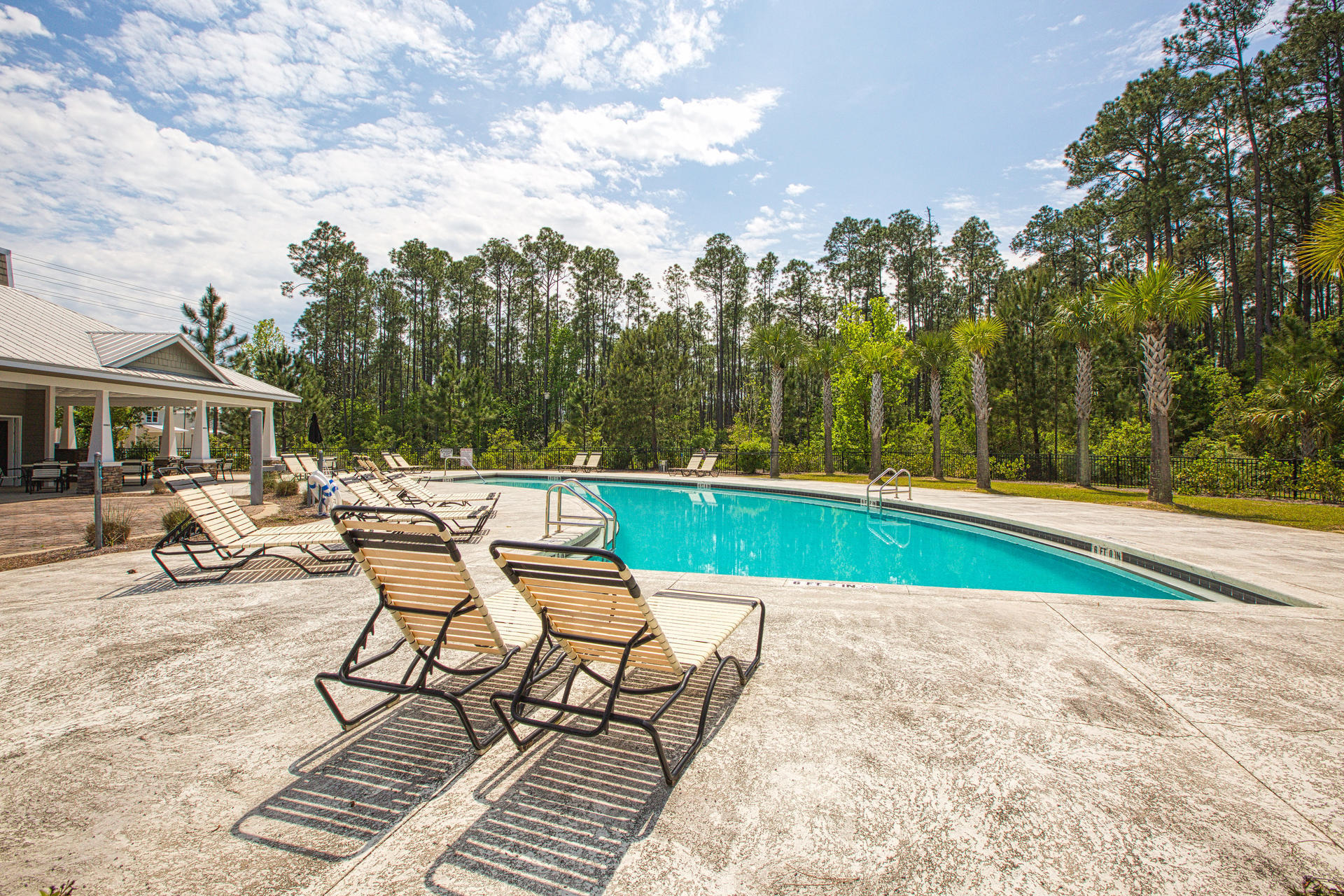 298 North Sand Palm Road, Unit 148 Freeport, FL 32439 - Photo 22 of 24 a view of swimming pool that has lawn chairs with plants and trees