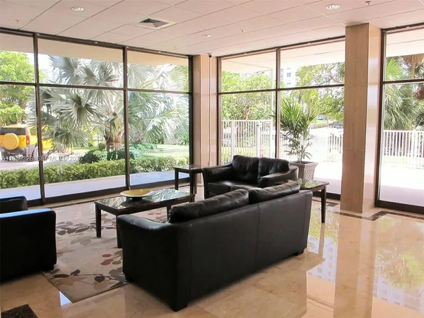 a living room with furniture and a floor to ceiling window