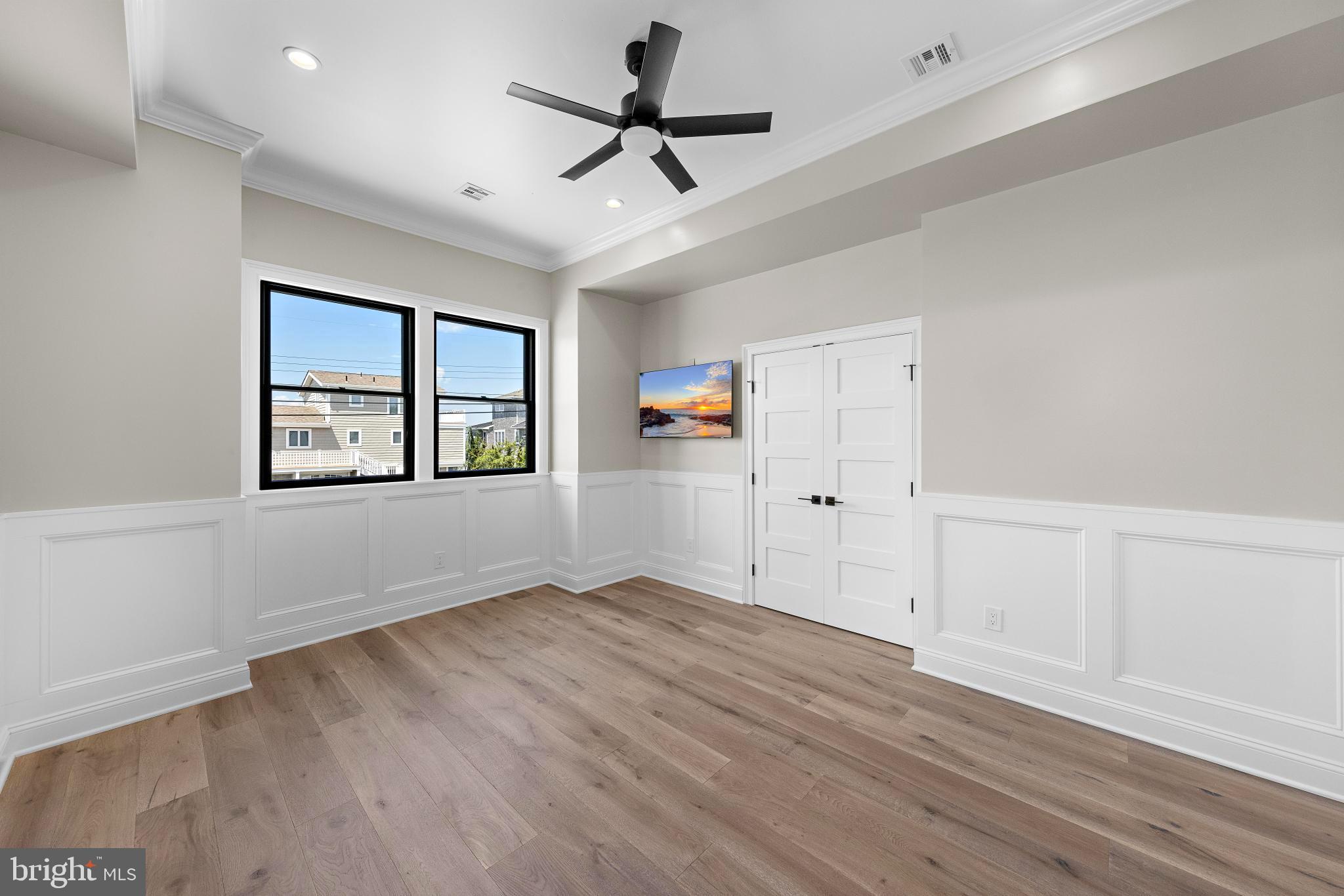 17 Butler Road Long Beach Township, NJ 08006 - Photo 58 of 110 an empty room with wooden floor ceiling fan and windows