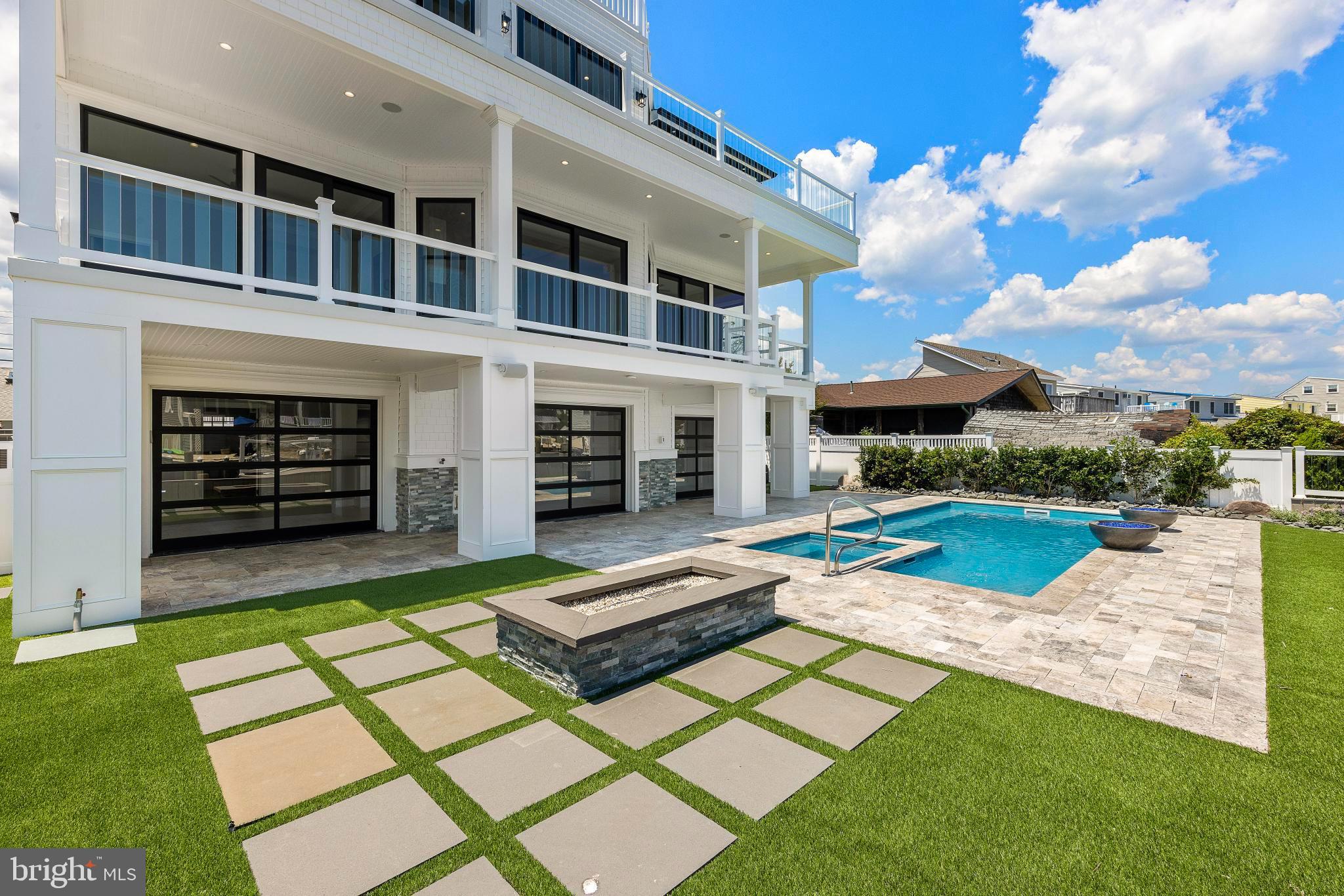 17 Butler Road Long Beach Township, NJ 08006 - Photo 81 of 110 a view of a house with pool fire pit and couches in a yard