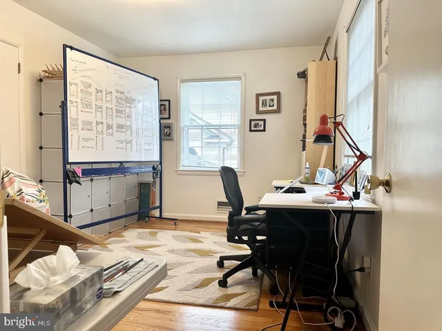 a view of a workspace with furniture and a window