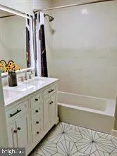 a bathroom with a double vanity sink toilet and shower