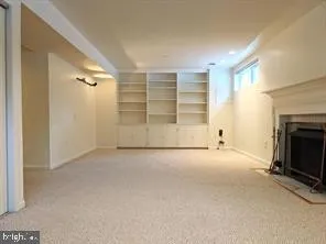 a view of an empty room with a fireplace and window