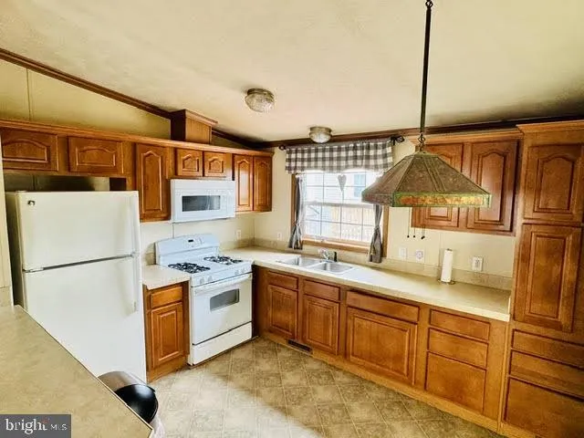 a kitchen with a sink a refrigerator and window