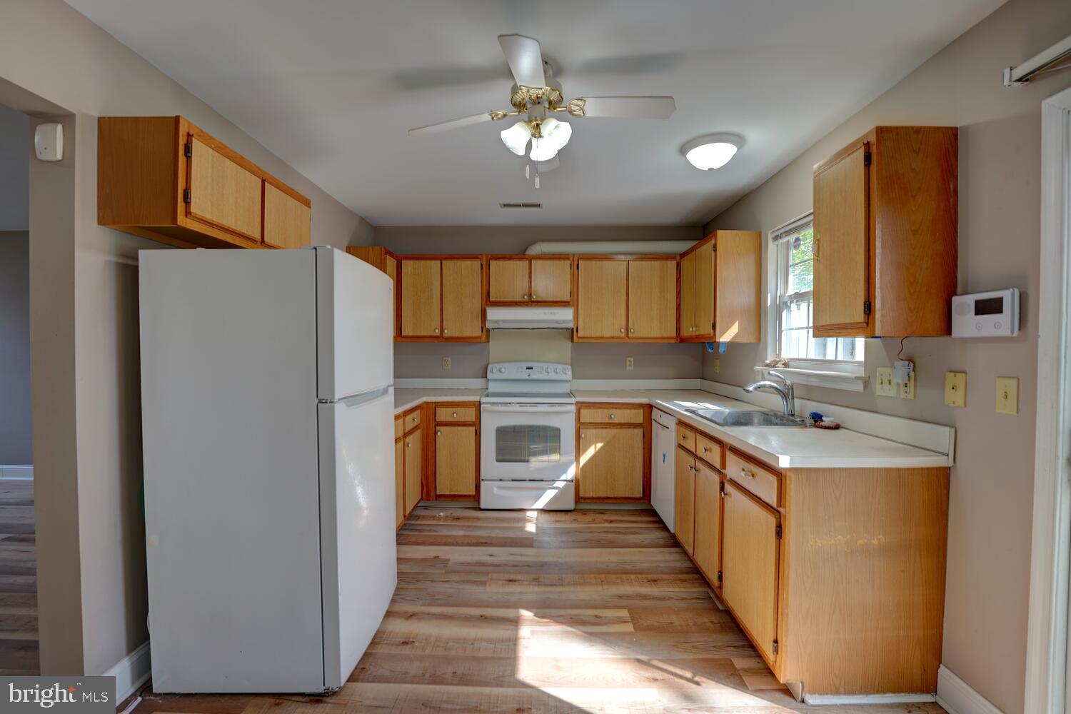 121 Periwinkle Drive Dover, DE 19904 - Photo 11 of 35 a kitchen with stainless steel appliances granite countertop a refrigerator a sink dishwasher a stove with wooden cabinets and floor
