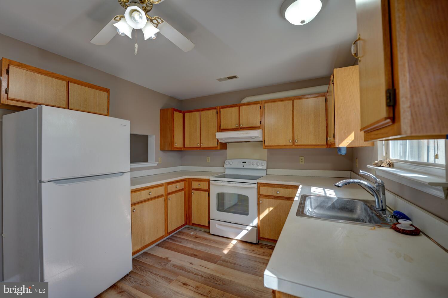 121 Periwinkle Drive Dover, DE 19904 - Photo 13 of 35 a kitchen with stainless steel appliances granite countertop a refrigerator a sink dishwasher a stove with wooden cabinets and floor