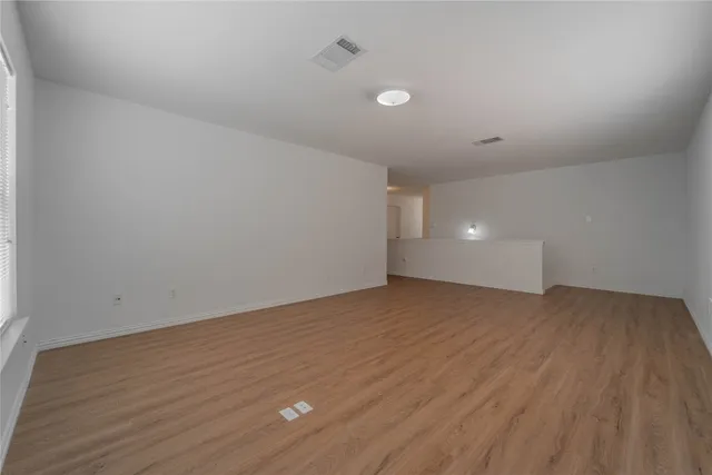 a view of an empty room and wooden floor