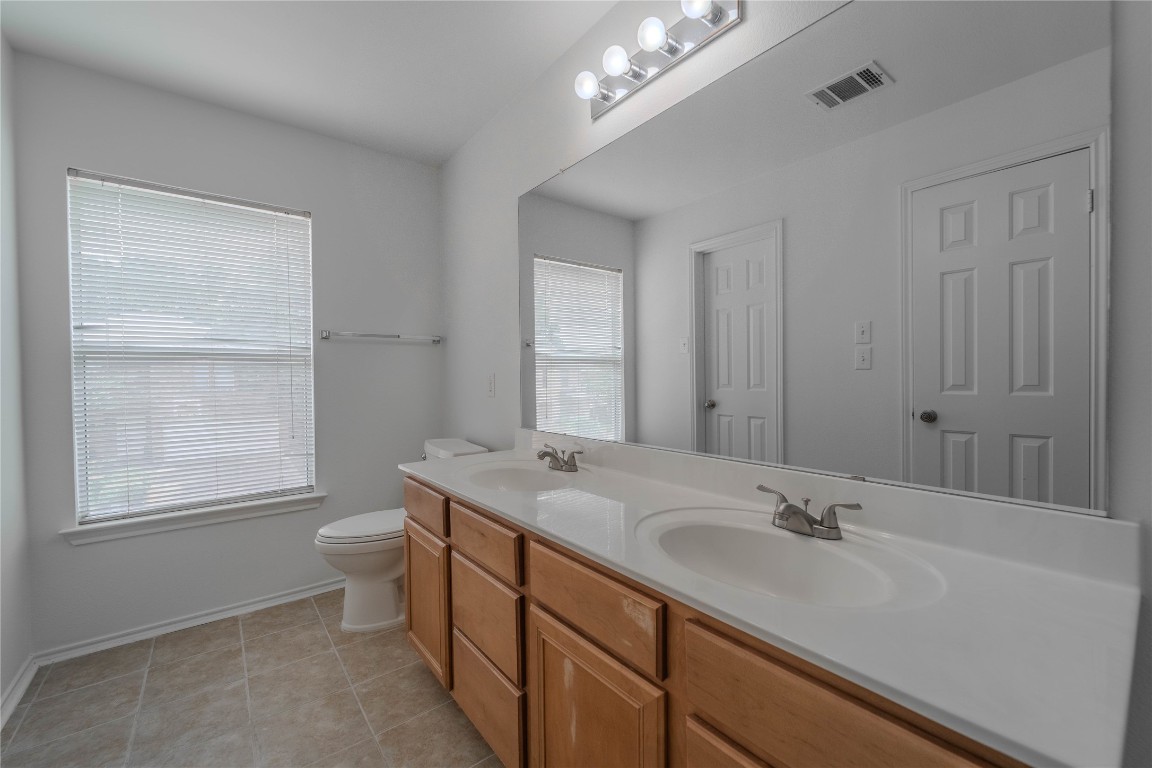 2000 Elk Ridge Cove Round Rock, TX 78665 - Photo 23 of 27 a bathroom with a sink double vanity granite and a toilet