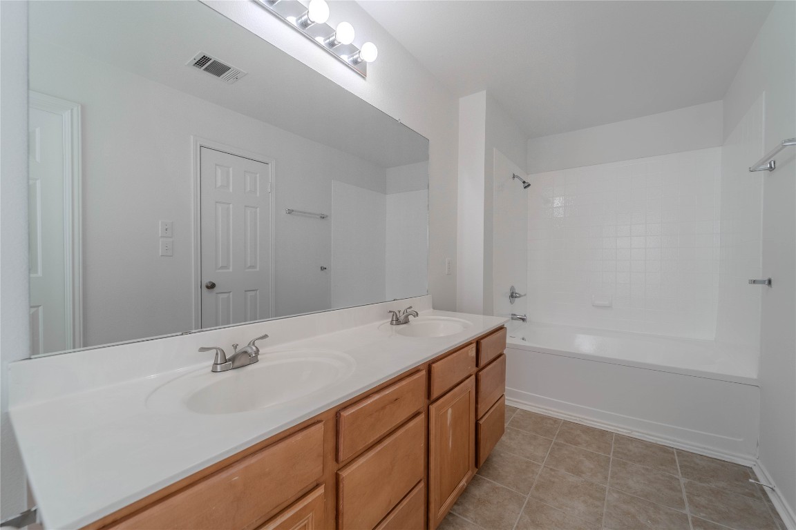 2000 Elk Ridge Cove Round Rock, TX 78665 - Photo 24 of 27 a bathroom with a sink double vanity granite tub shower and a mirror