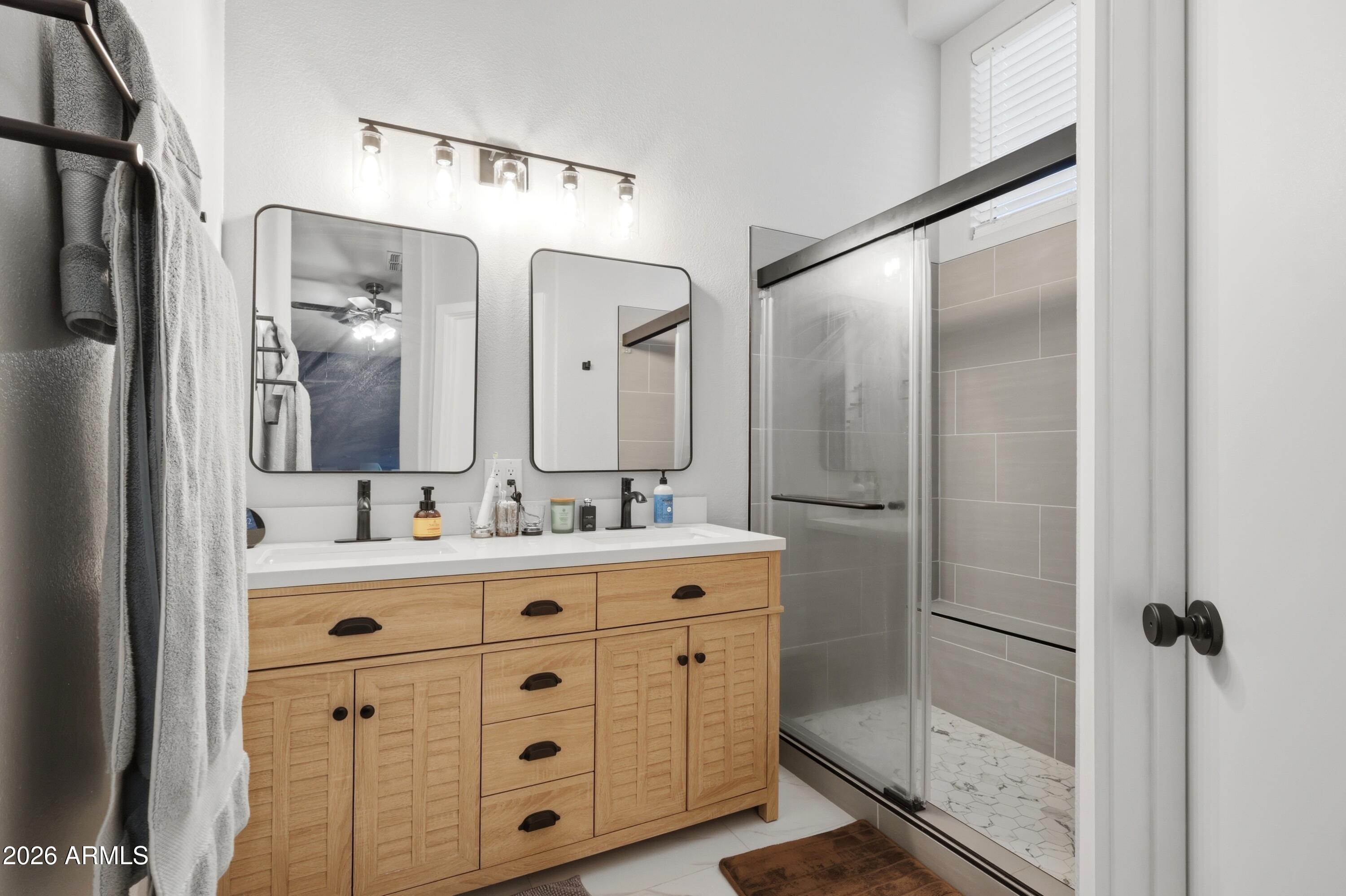 661 North Joshua Tree Lane Gilbert, AZ 85234 - Photo 23 of 47 a bathroom with a double vanity sink mirror and shower