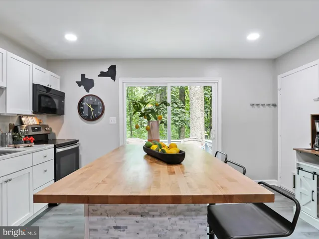 a room with stainless steel appliances furniture kitchen view and wooden floor