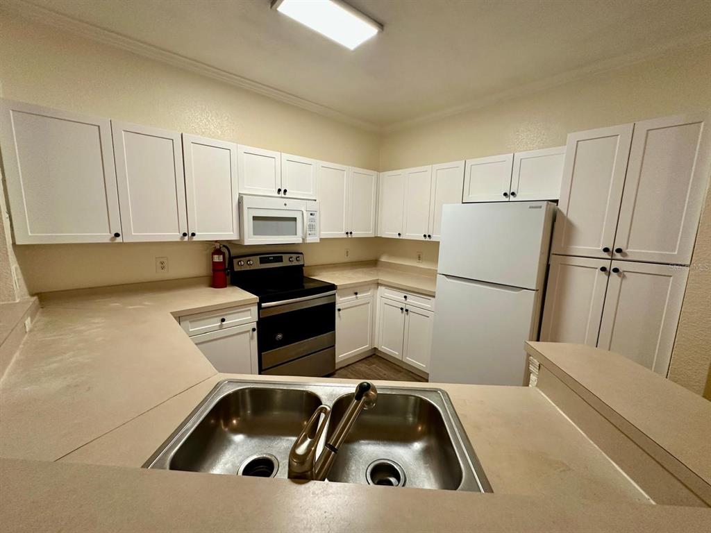3561 Conroy Road, Unit 215 Orlando, FL 32839 - Photo 15 of 43 a kitchen with a sink cabinets and stainless steel appliances