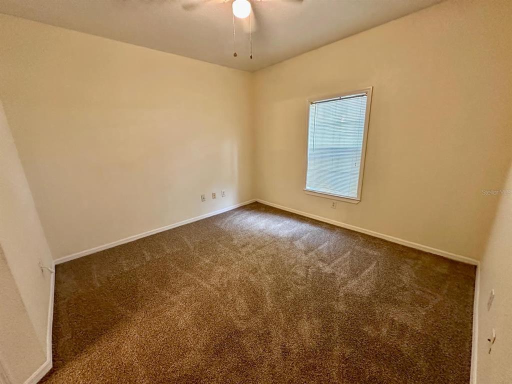 3561 Conroy Road, Unit 215 Orlando, FL 32839 - Photo 22 of 43 an empty room with a chandelier fan and windows