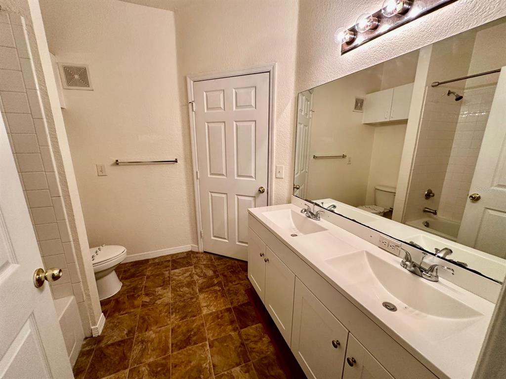3561 Conroy Road, Unit 215 Orlando, FL 32839 - Photo 26 of 43 a bathroom with a double vanity sink and mirror with toilet