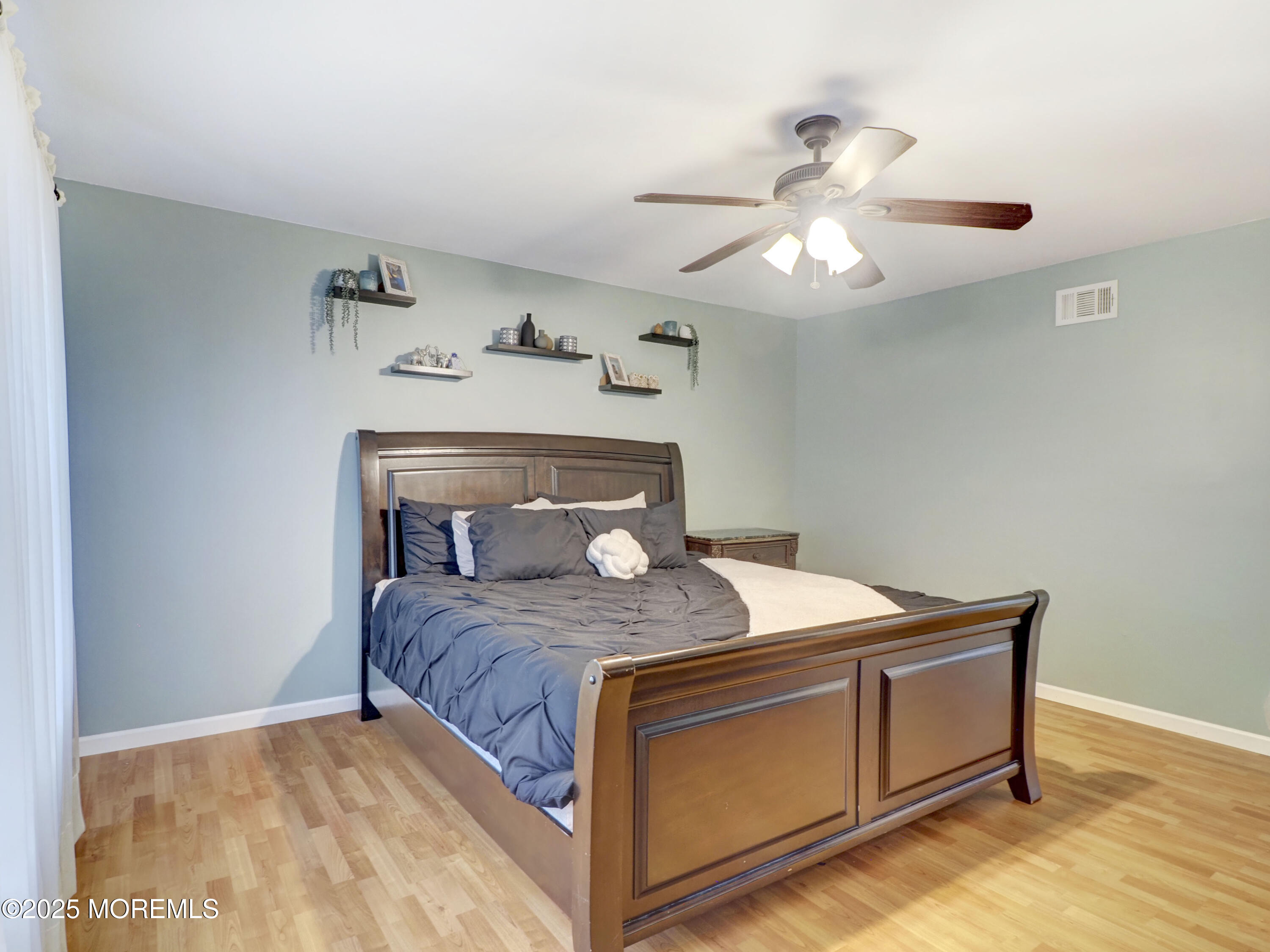 82 Cliffwood Avenue West, Unit 25D Cliffwood, NJ 07721 - Photo 26 of 27 a bedroom with a bed and a chandelier