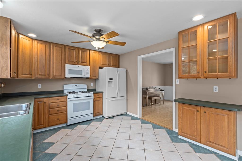 1552 Cathell Road Pittsburgh, PA 15236 - Photo 12 of 34 a kitchen with a refrigerator a stove top oven a sink dishwasher and a refrigerator with wooden cabinets