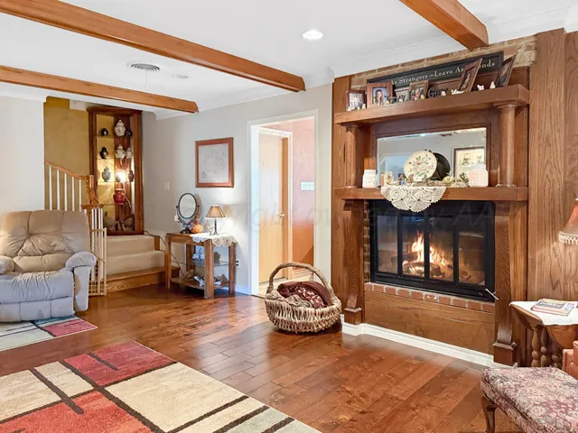 a living room with furniture kitchen view and a large window