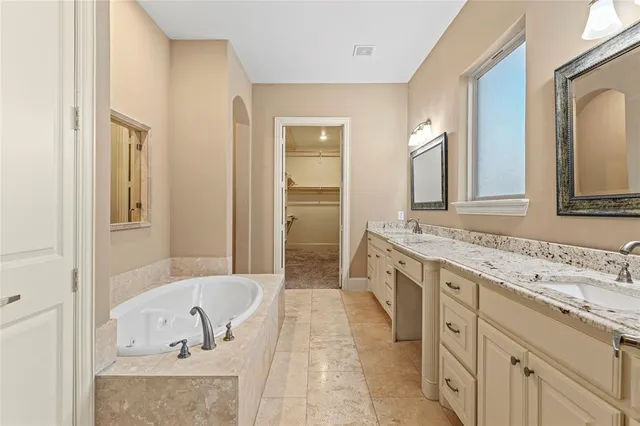 a spacious bathroom with a tub sink and mirror