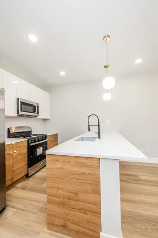 a kitchen with stainless steel appliances granite countertop a sink a stove top oven and white appliances