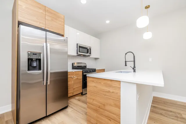a kitchen with kitchen island a counter top a sink appliances and cabinets